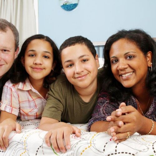a family consisting of a father on the left and mother on the right with a boy and girl between them