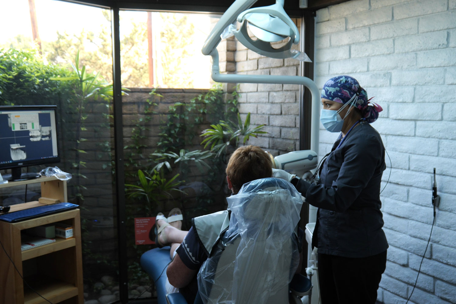 Dental assistant at Temple City Dental Care capturing x-ray images for a patient.