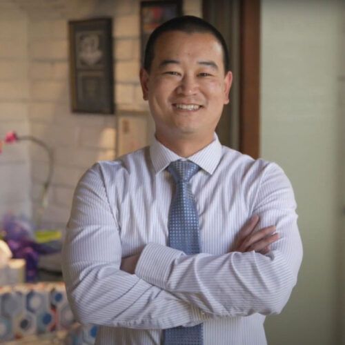 Dr. Kyle Low smiling with his hand folded.