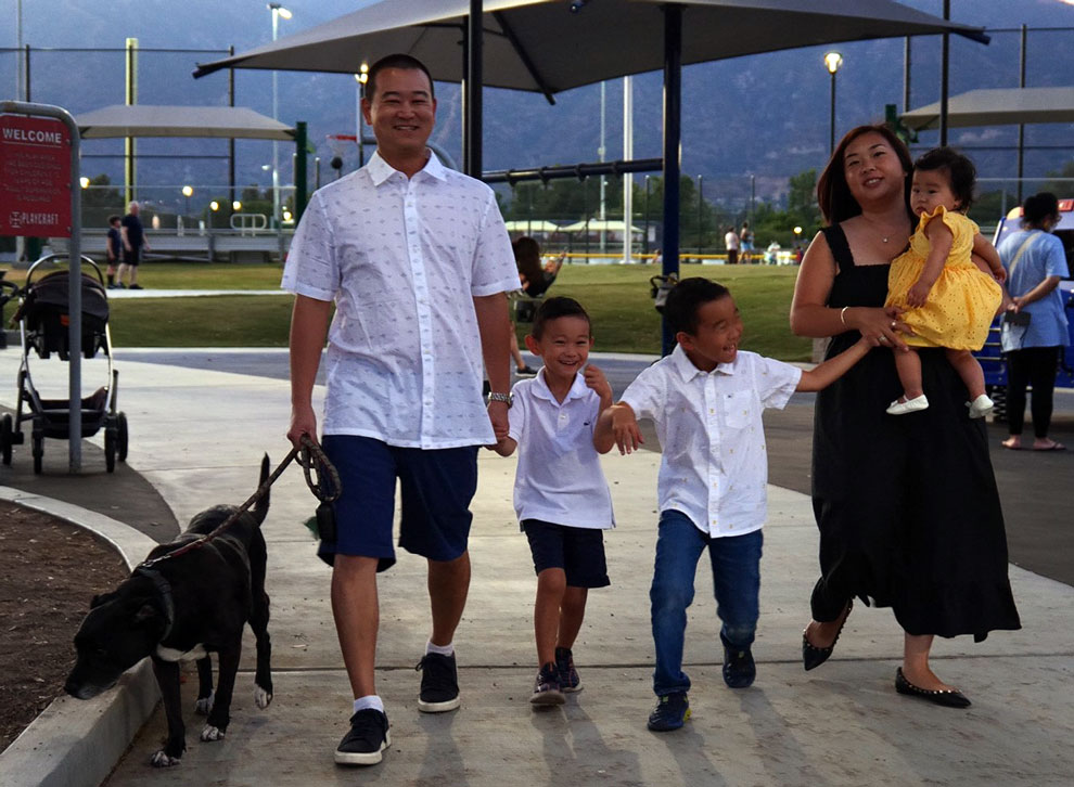 Dr. Kyle talking with family, two small boys, wife hold their baby girl.