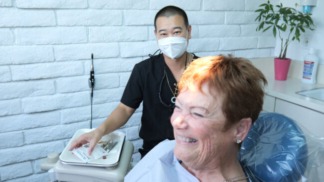 Dr. Kyle Low with patient in chair smiling.