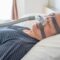Man using a CPAP machine while he sleeps to treat sleep apnea