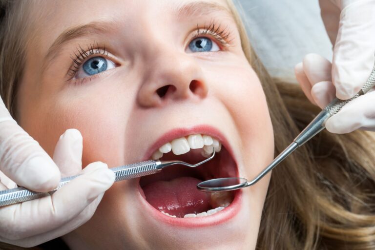 Little girl having dental check up. Dentist looking for cavaties in a child's mouth